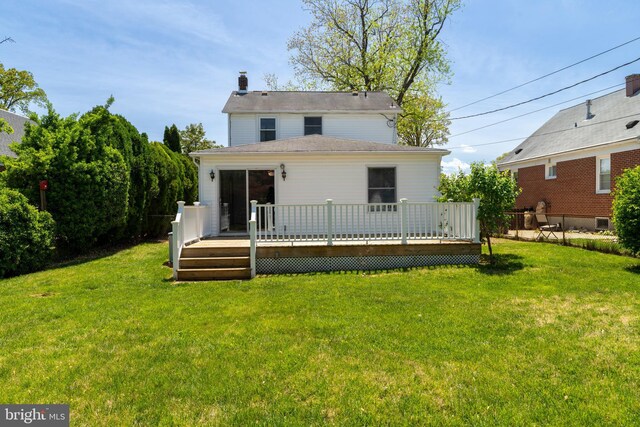 back of house with a lawn, a chimney, and a deck