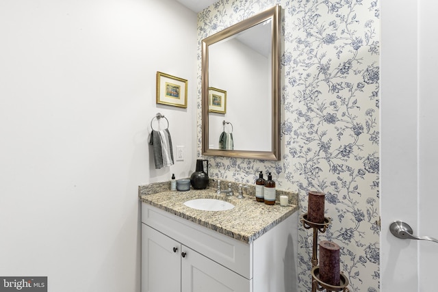 bathroom featuring wallpapered walls and vanity