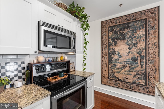 kitchen with appliances with stainless steel finishes, tasteful backsplash, light stone countertops, dark wood finished floors, and white cabinetry