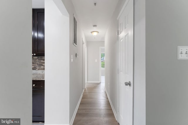 hall with baseboards and wood finished floors