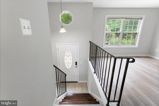 stairway with wood finished floors and baseboards