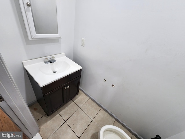 bathroom featuring vanity, tile patterned flooring, baseboards, and toilet