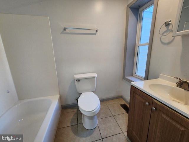 bathroom featuring vanity, toilet, tile patterned floors, baseboards, and a tub to relax in