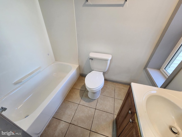 full bath featuring vanity, tile patterned floors, toilet, and a washtub