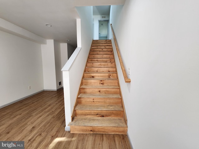 stairs with baseboards, recessed lighting, wood finished floors, and visible vents