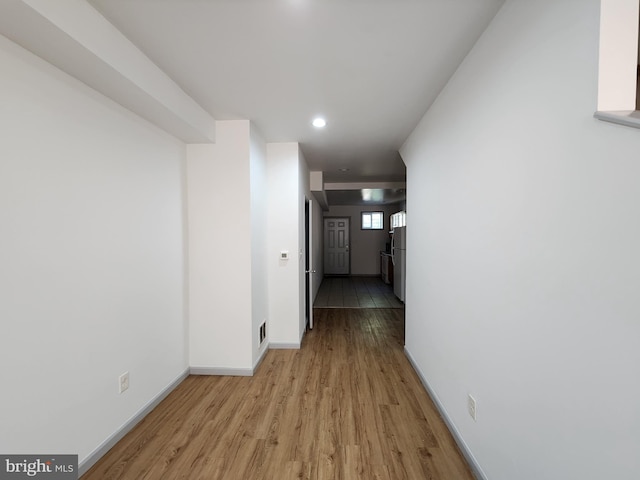 hall with baseboards, recessed lighting, light wood-style flooring, and visible vents