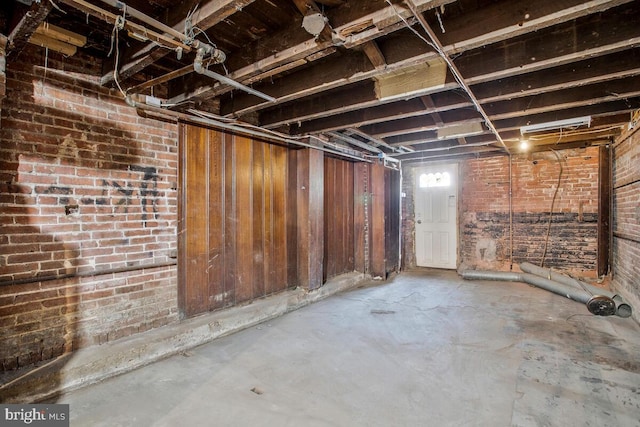 basement with wooden walls and brick wall