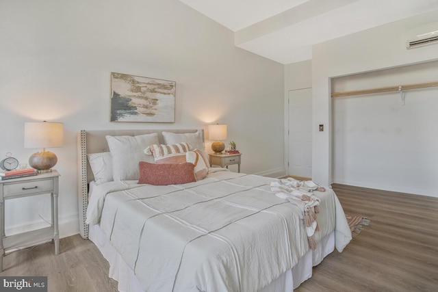 bedroom featuring a closet, baseboards, wood finished floors, and visible vents