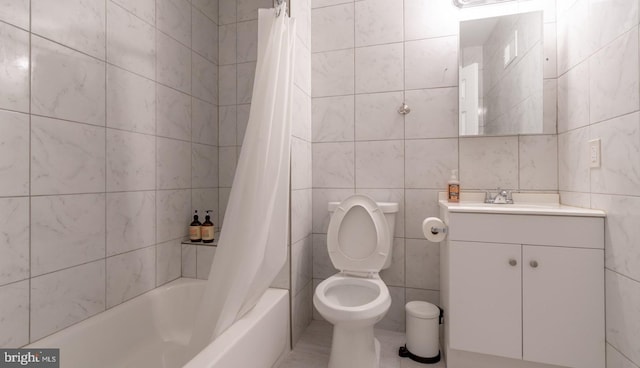 full bath with tile walls, vanity, toilet, and shower / tub combo