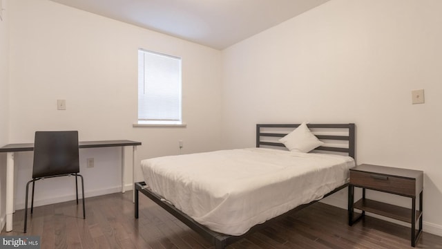 bedroom featuring baseboards and wood finished floors