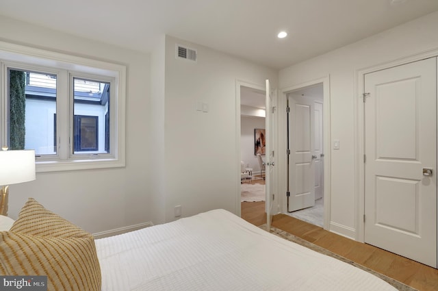 bedroom with recessed lighting, baseboards, light wood-type flooring, and visible vents