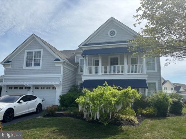 view of front of property featuring a balcony and a garage