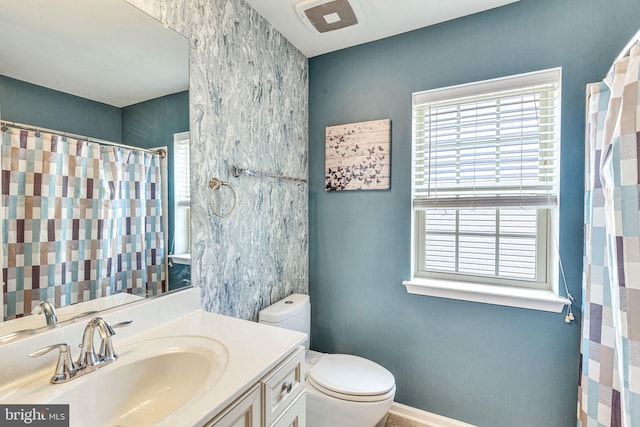 full bath with healthy amount of natural light, toilet, vanity, and curtained shower