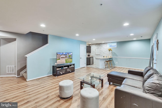 living room with light wood finished floors, recessed lighting, visible vents, and stairs