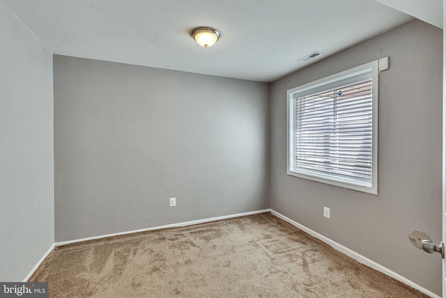 carpeted spare room featuring baseboards