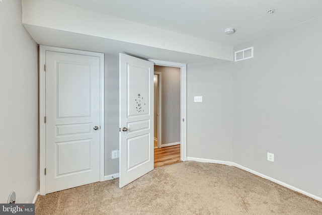 unfurnished bedroom featuring light colored carpet and baseboards