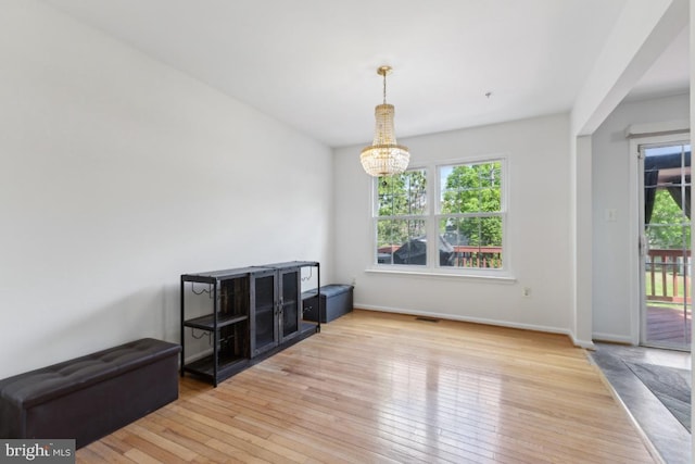 11408 Leland Pl, Waldorf, MD 20601 - unfurnished dining area with a chandelier, hardwood / wood-style floors, and baseboards