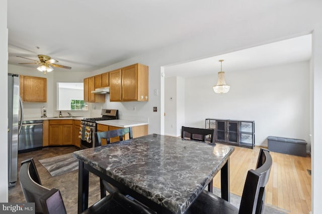 11408 Leland Pl, Waldorf, MD 20601 - kitchen featuring stainless steel appliances, a ceiling fan, a sink, under cabinet range hood, and a breakfast bar