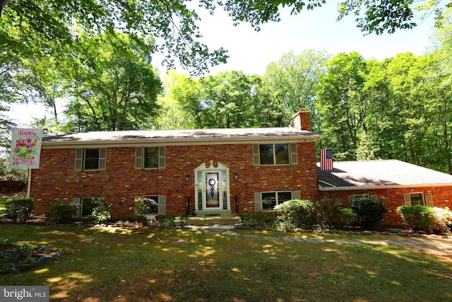 3901 Stoneybrook Rd, White Plains, MD 20695 - raised ranch with a chimney, a front lawn, and brick siding