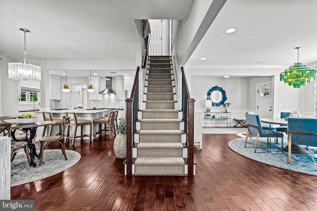 staircase with a chandelier and wood-type flooring