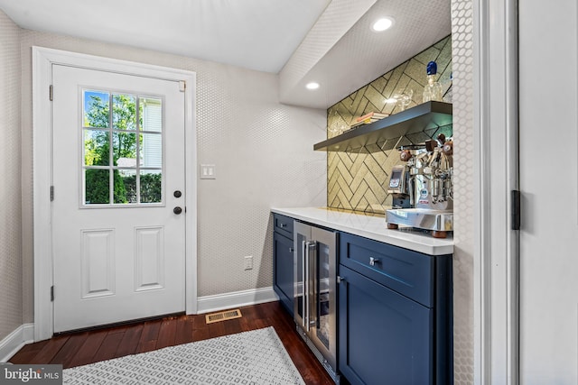 indoor dry bar featuring beverage cooler, baseboards, dark wood finished floors, tasteful backsplash, and recessed lighting