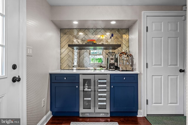 indoor dry bar with wine cooler, dark wood-style floors, baseboards, and decorative backsplash