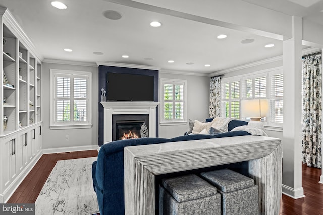 living room with ornamental molding, dark wood-style floors, a glass covered fireplace, recessed lighting, and baseboards