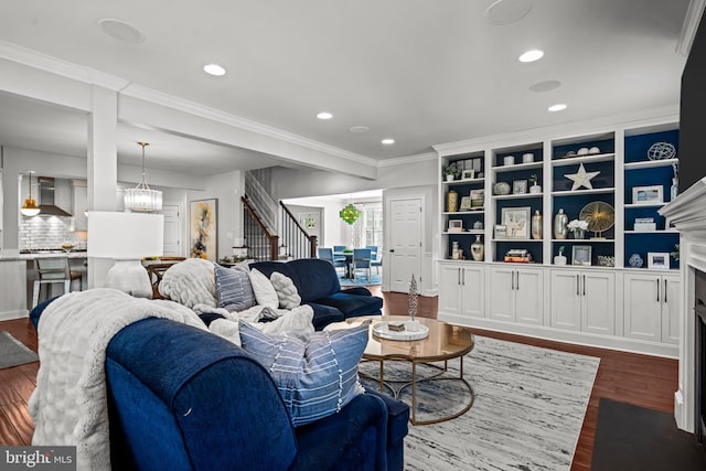 living area with stairway, dark wood-style flooring, ornamental molding, a fireplace with flush hearth, and recessed lighting