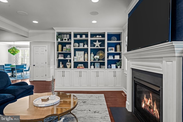 living room with ornamental molding, a fireplace with flush hearth, dark wood-style floors, recessed lighting, and built in features