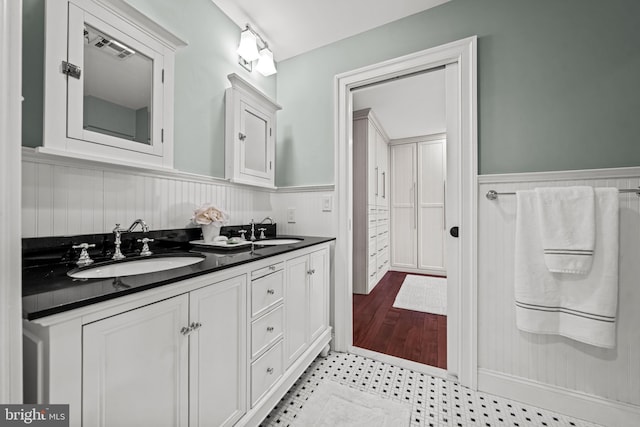 bathroom with wainscoting and double vanity