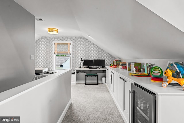 bar with wine cooler, lofted ceiling, light carpet, wallpapered walls, and baseboards