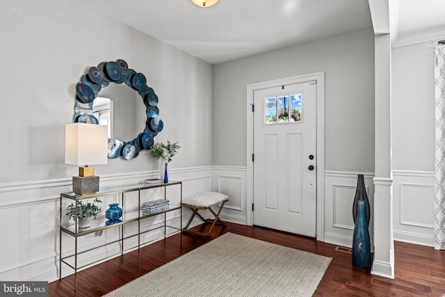 entrance foyer featuring a wainscoted wall, wood finished floors, and a decorative wall