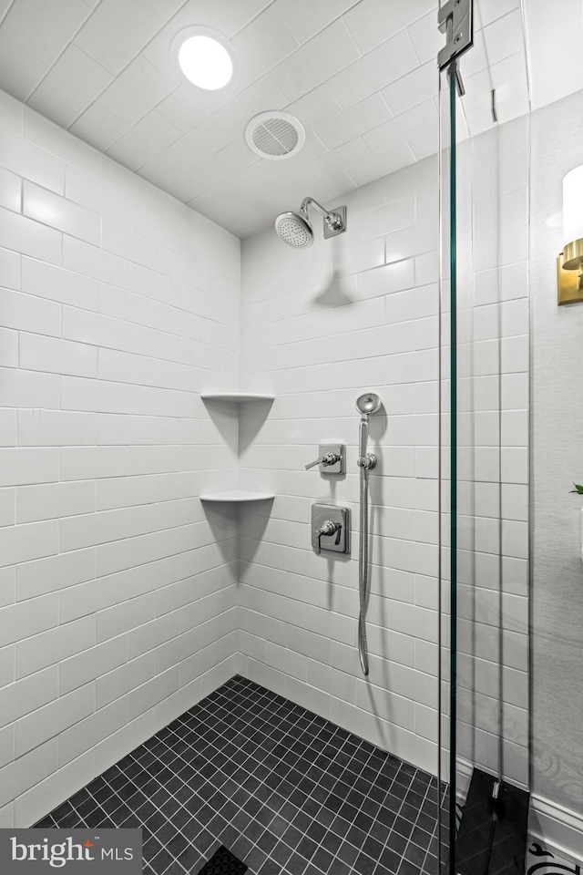 full bathroom featuring tiled shower and tile patterned flooring