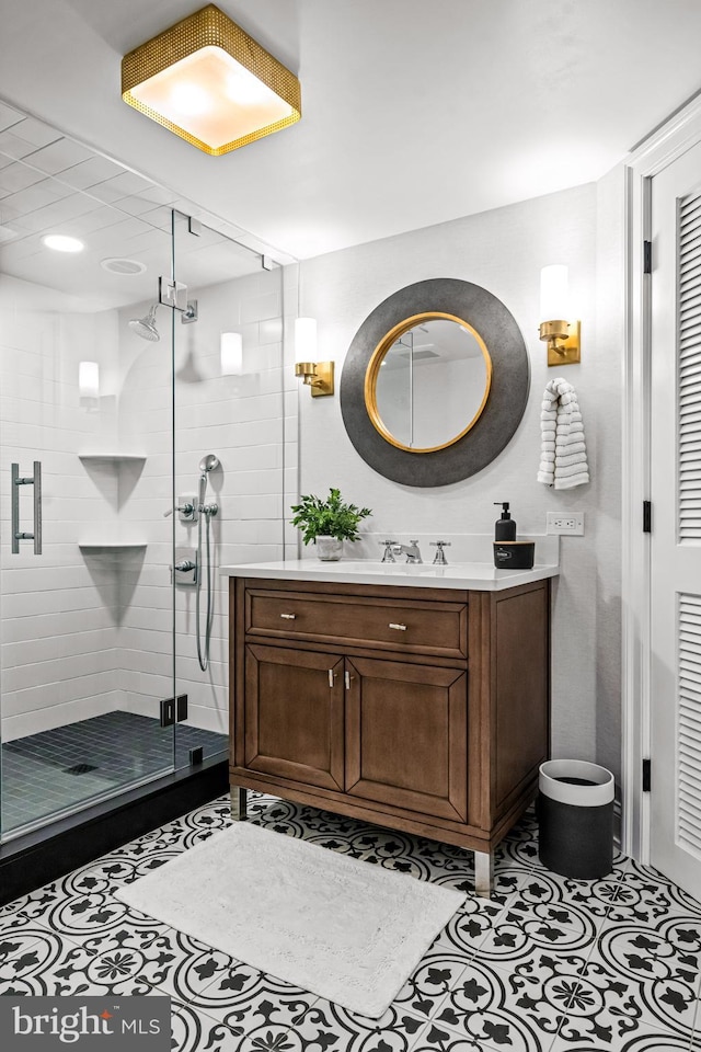 full bathroom featuring a shower stall, vanity, and tile patterned flooring