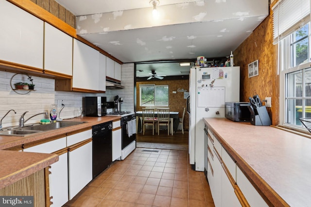 kitchen with gas range oven, a sink, black dishwasher, and white cabinetry