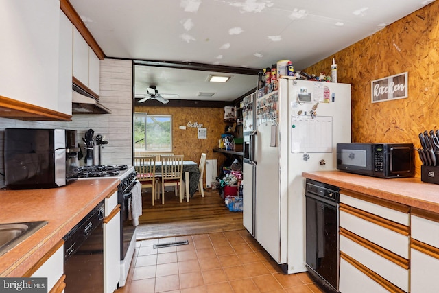 kitchen featuring black appliances, white cabinets, under cabinet range hood, light countertops, and ceiling fan