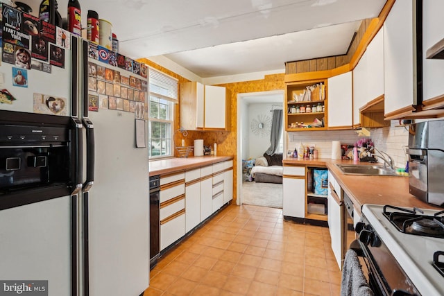 kitchen featuring white fridge with ice dispenser, a sink, white cabinetry, open shelves, and backsplash