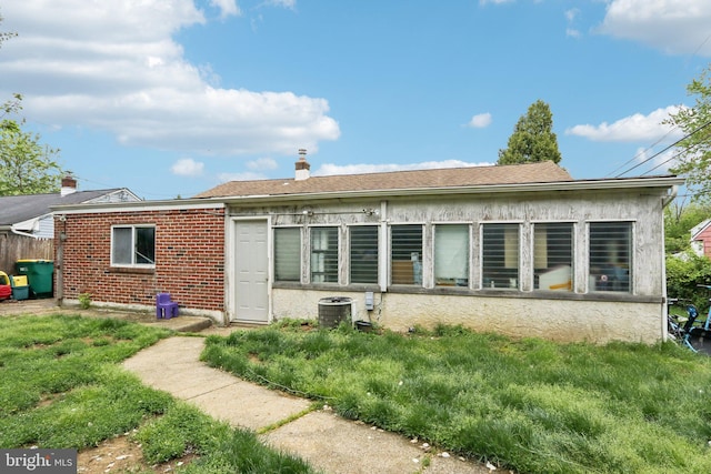 rear view of property featuring central air condition unit and brick siding
