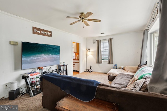 living room with carpet floors, ceiling fan, and crown molding