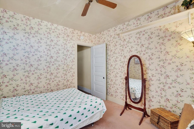 carpeted bedroom with ceiling fan and wallpapered walls