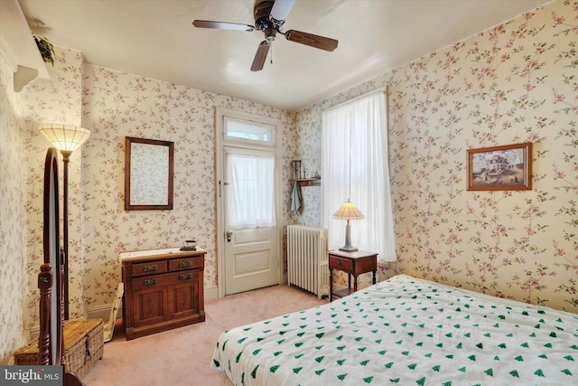 bedroom with radiator heating unit, ceiling fan, wallpapered walls, and light colored carpet