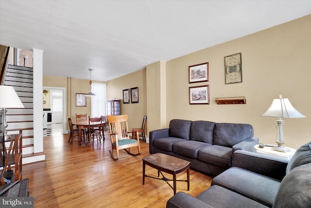 living area with light wood-style floors and stairway