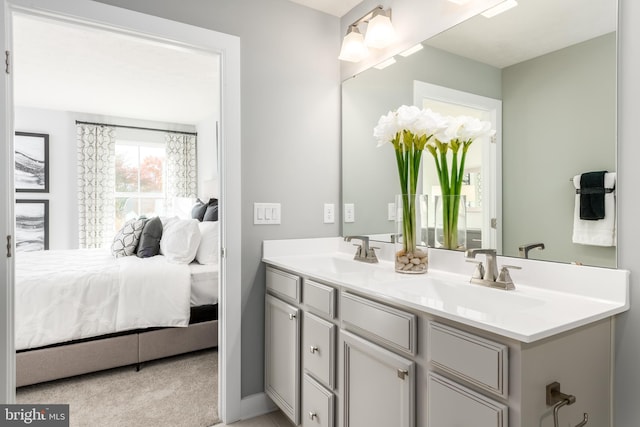 full bath featuring double vanity, a sink, and connected bathroom