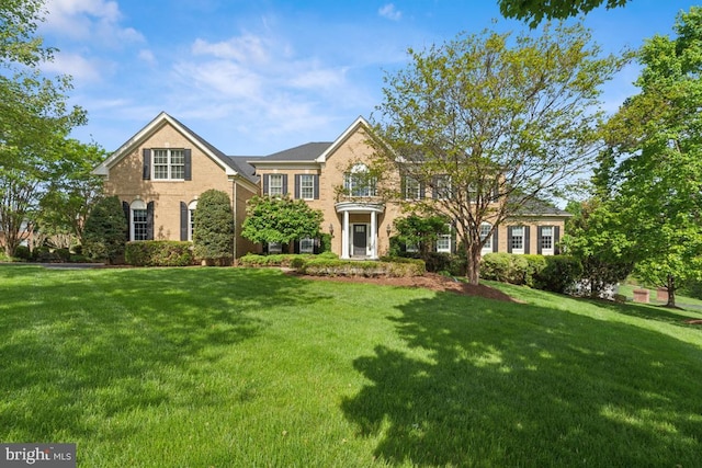 view of front of house with brick siding and a front yard