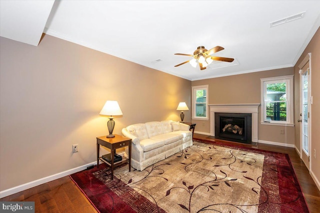 living area with visible vents, baseboards, ceiling fan, and wood finished floors