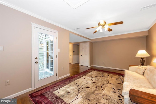 living room with baseboards, visible vents, ornamental molding, and wood finished floors