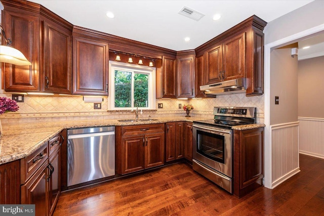 kitchen with visible vents, dark wood-style flooring, under cabinet range hood, a sink, and stainless steel appliances