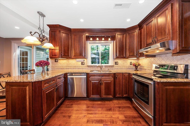 kitchen with visible vents, a sink, a peninsula, under cabinet range hood, and stainless steel appliances
