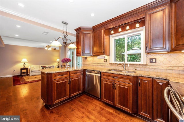 kitchen with tasteful backsplash, a sink, a peninsula, stainless steel appliances, and dark wood-type flooring