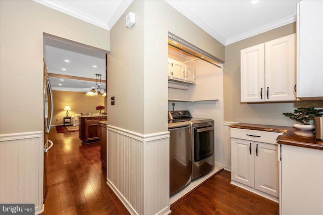 kitchen featuring crown molding, dark wood-type flooring, and washer and clothes dryer